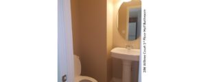 Half bathroom with pedestal sink, mirror, and toilet