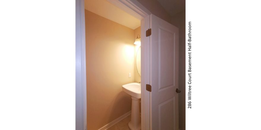 Half bathroom with pedestal sink and mirror