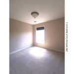 Carpeted bedroom with window and light fixture