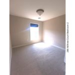 Carpeted bedroom with window and light fixture