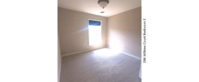 Carpeted bedroom with window and light fixture