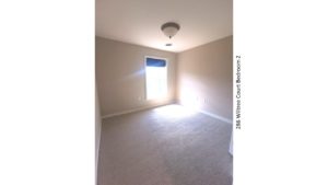 Carpeted bedroom with window and light fixture