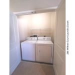 Laundry closet with side-by-side washer and dryer and shelving