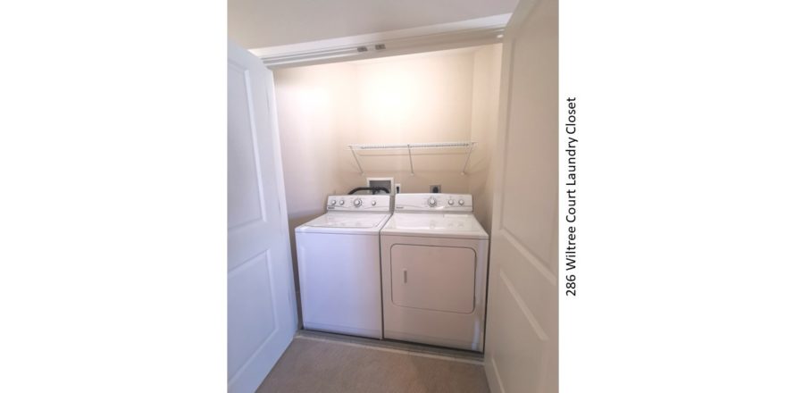 Laundry closet with side-by-side washer and dryer and shelving