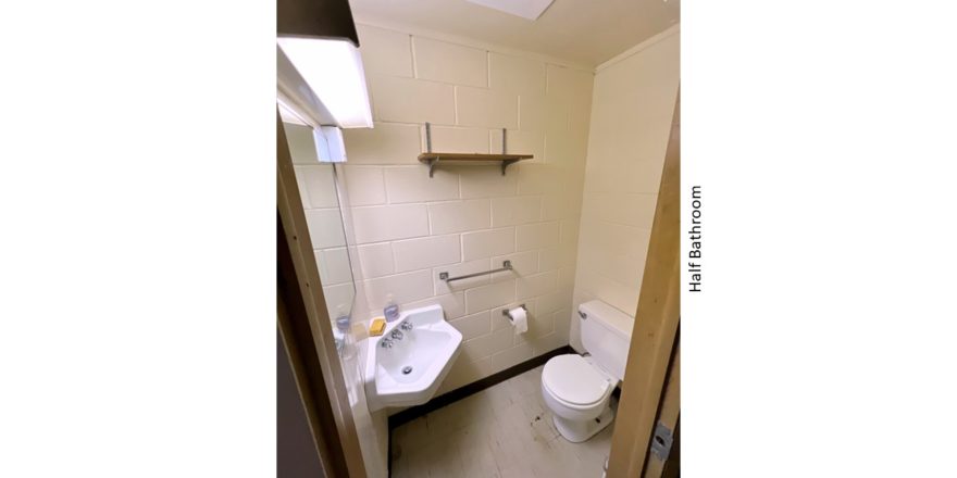 Half bathroom with wall-mounted sink and toilet