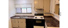 Kitchen with light gray cabinets, white and black range oven, and black dishwasher