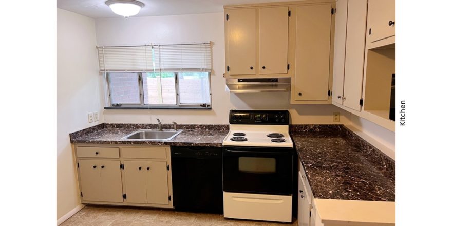 Kitchen with light gray cabinets, white and black range oven, and black dishwasher