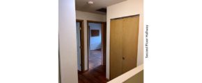 Hallway with closet and hardwood floors