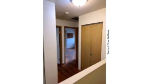 Hallway with closet and hardwood floors