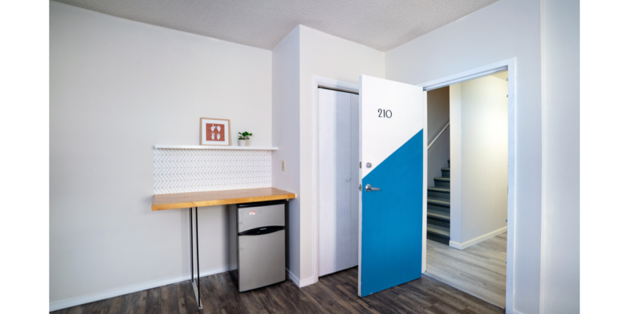 Room with shelf and decorations, countertop, and mini-fridge