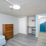 Room with bed, dresser, mini fridge, countertop and shelf