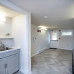 Hallway with sink, decorations, mirror and door