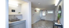 Hallway with sink, decorations, mirror and door