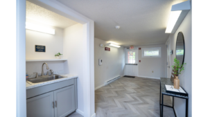 Hallway with sink, decorations, mirror and door