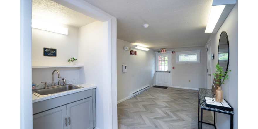 Hallway with sink, decorations, mirror and door