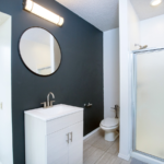 Bathroom with mirror, vanity, toilet, and shower stall