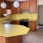 Kitchen with yellow countertops, wood-tone cabinets and appliances