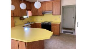 Kitchen with yellow countertops, wood-tone cabinets and appliances