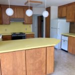Kitchen with yellow countertops, wood-tone cabinets and appliances