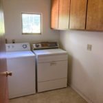 Laundry room with washer and dryer and wood-tone cabinets