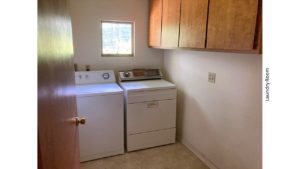 Laundry room with washer and dryer and wood-tone cabinets