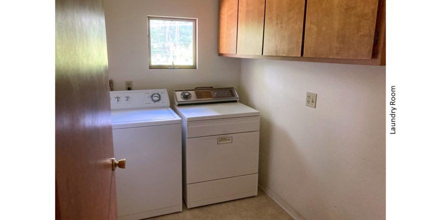 Laundry room with washer and dryer and wood-tone cabinets