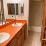 Bathroom with double vanity, toilet, and tub/shower combo