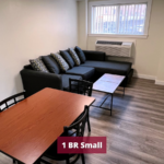Living room with laminate flooring, dining table, coffee table, air conditioner, and sofa
