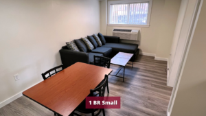 Living room with laminate flooring, dining table, coffee table, air conditioner, and sofa