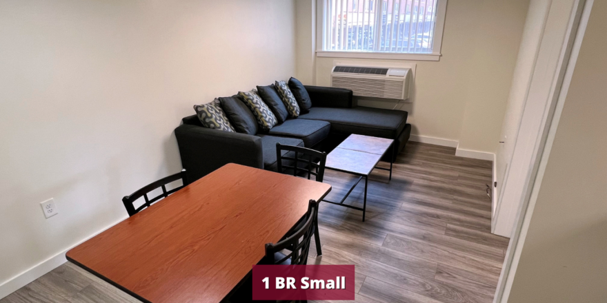 Living room with laminate flooring, dining table, coffee table, air conditioner, and sofa