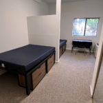 Bedroom with full-size beds, desk with chair, and small dressers