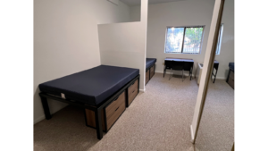 Bedroom with full-size beds, desk with chair, and small dressers