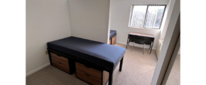 Bedroom with twin-size beds, desk with chair, and small dressers