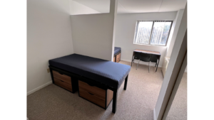 Bedroom with twin-size beds, desk with chair, and small dressers