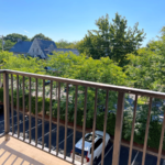 Balcony with view of parking lot and trees