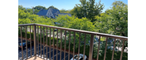 Balcony with view of parking lot and trees