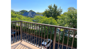 Balcony with view of parking lot and trees