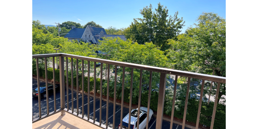 Balcony with view of parking lot and trees