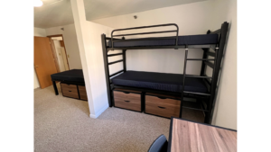 Bedroom with twin-size bed, bunk bed, desk with chair, and small dressers