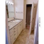 Bathroom with ceramic tile flooring, large vanity, and mirror