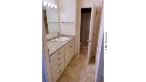 Bathroom with ceramic tile flooring, large vanity, and mirror