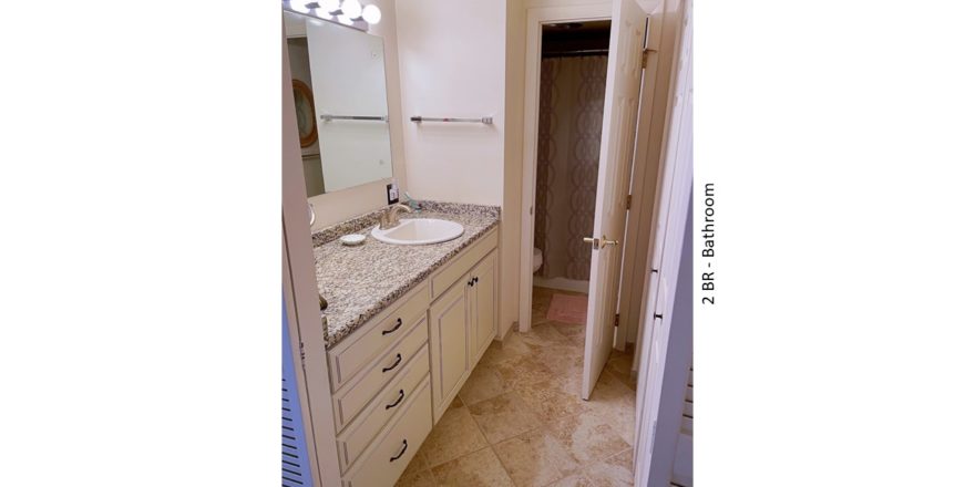 Bathroom with ceramic tile flooring, large vanity, and mirror