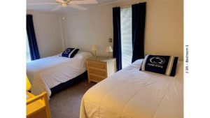 Bedroom with beds, dressers, lamps, ceiling fan, blinds, and curtains