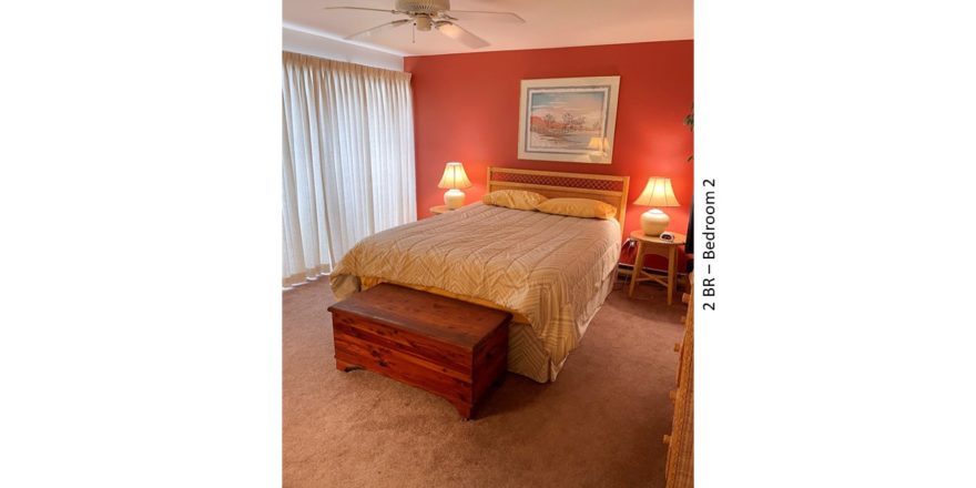Bedroom with bed, night stands, lamps, chest, painting, ceiling fan, and curtains