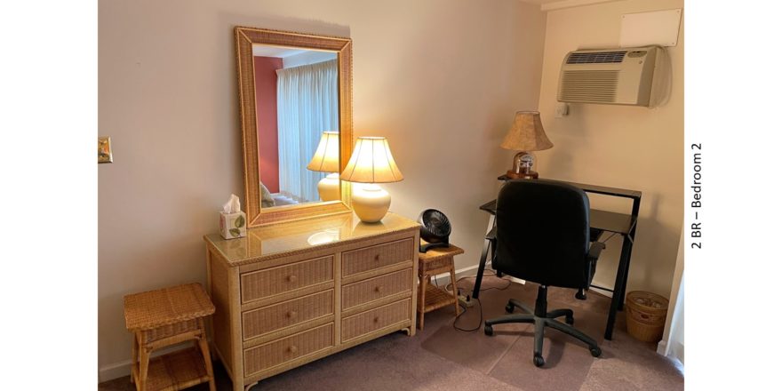 Bedroom with desk, desk chair, end tables, dresser with mirror, and lamps