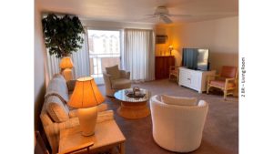 Living room with arm chairs, couch, lamps, end tables, coffee table, ceiling fan, and slider to balcony