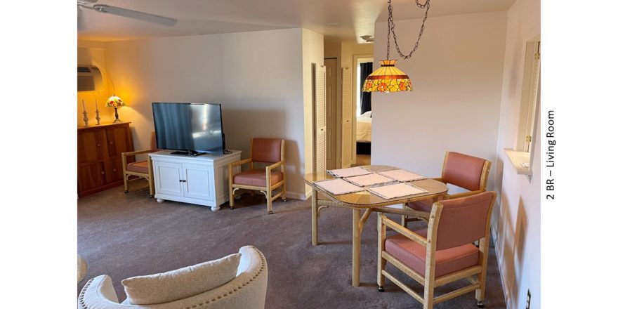 Living room with dining table and chairs, lamps, tv, tv stand, and arm chair