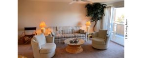 Living room with arm chairs, end tables, lamps, coffee table, couch, and fake plant