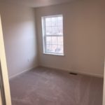 an empty room with carpet and a window