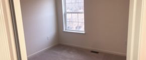 an empty room with carpet and a window